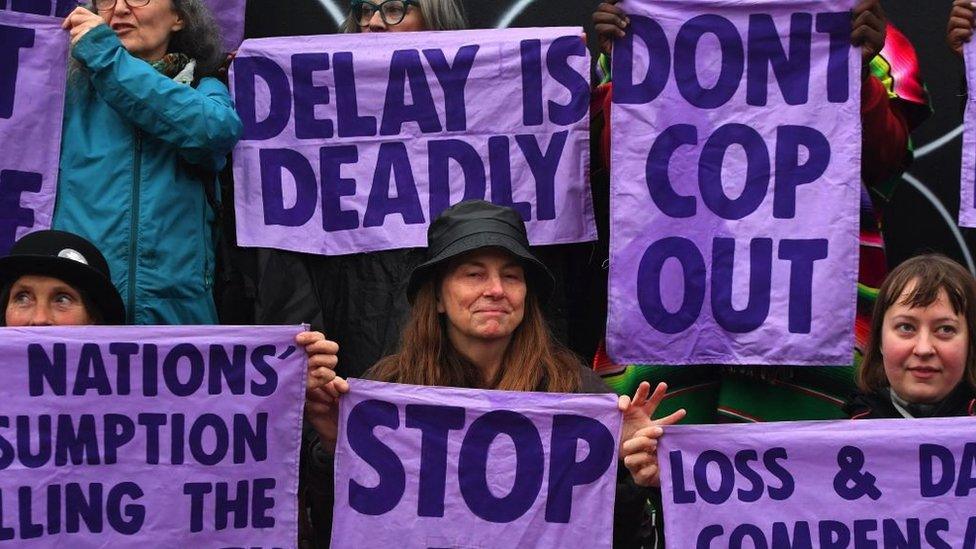 Members of climate action protest group Scientist Rebellion hold signs during a demonstration in Glasgow on the side lines of the COP26 UN Climate Change Summit