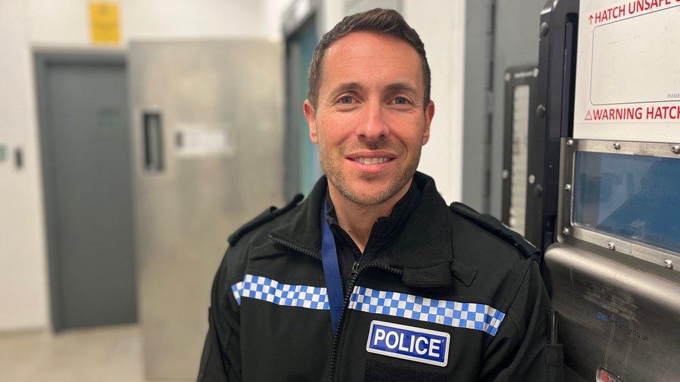 A police officer in a cell block