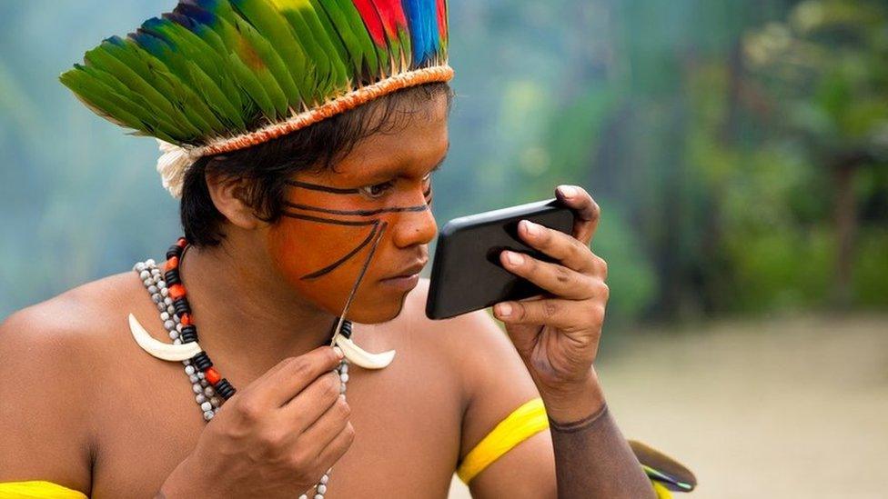 An indigenous man from the Tupi Guarani tribe in Brazil paints his face