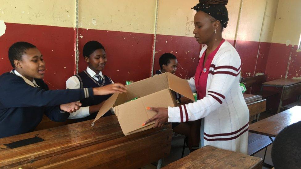 Nokuzola Ndwandwe handing pads to school girls