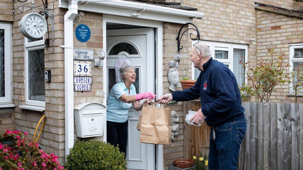 A volunteer delivering food