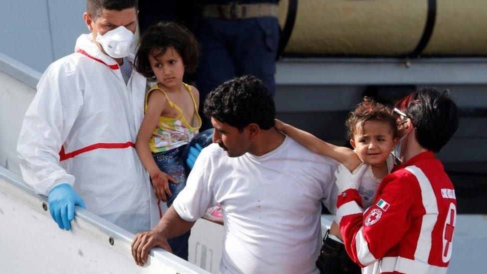 Migrants disembark from a Italian navy ships in Porto Empedocle, 26 May 26