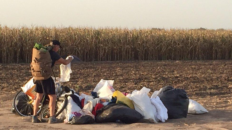 Hungarian man scavenges for clothes abandoned by fleeing refugees