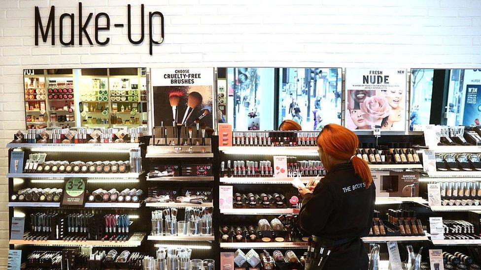 A Body Shop store assistant restocks the make-up section