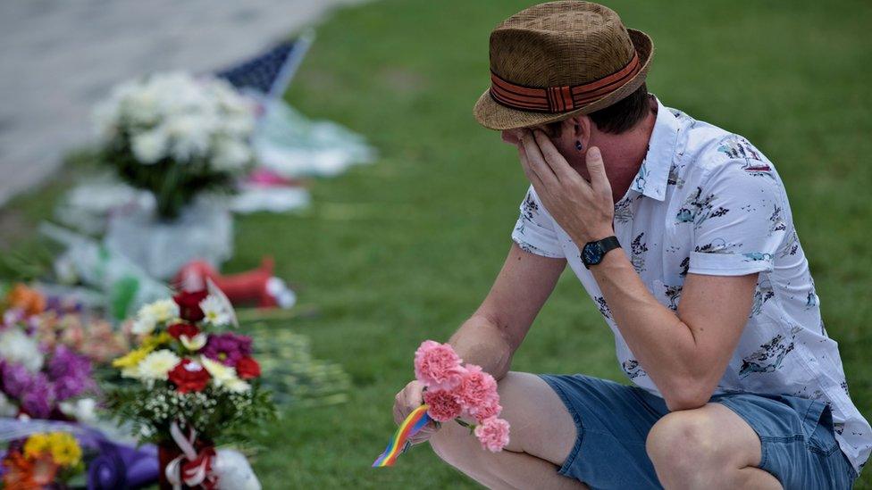 Jonathan Dalton who lost friends visits a makeshift memorial outside the Dr. Phillips Center for the Performing Arts for the mass shooting victims at the Pulse nightclub June 13, 2016 in Orlando, Florida.