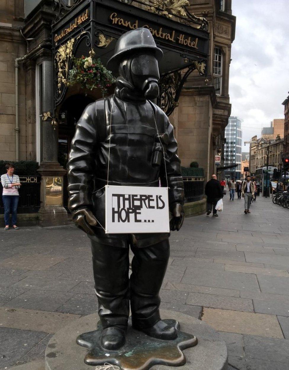 Firefighter statue with sign