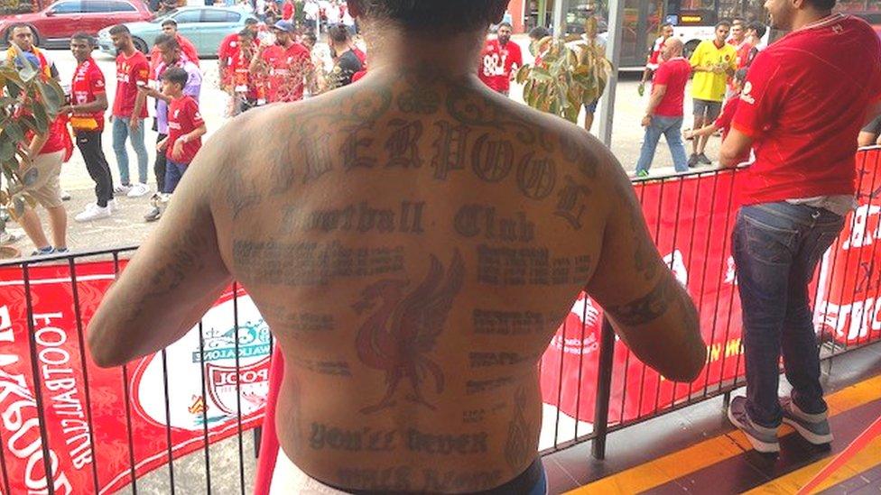 Liverpool fan Vijay shows off his tattoos.