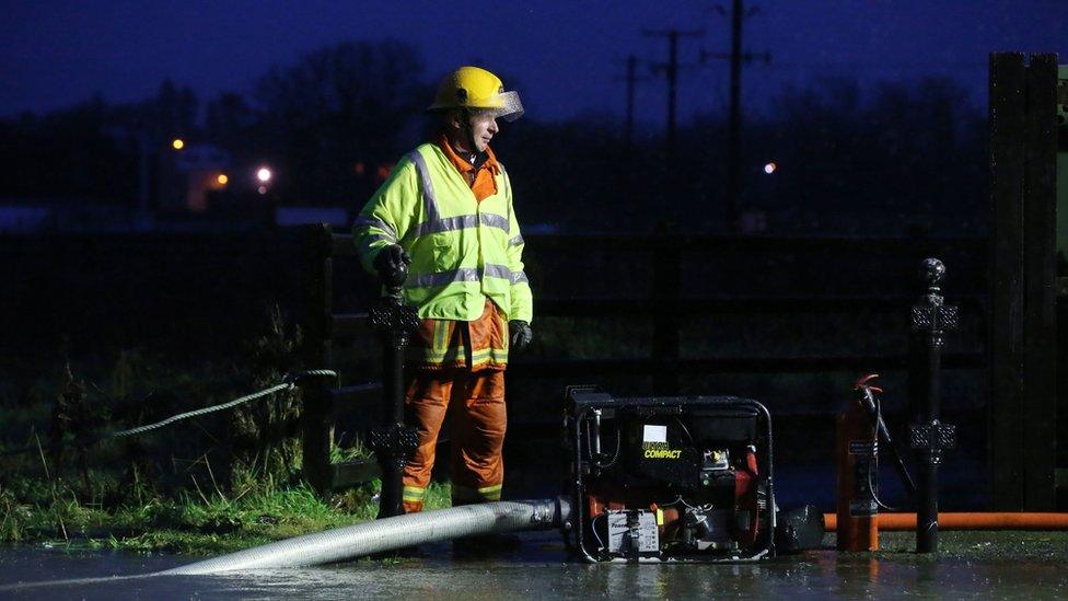 Fire fighter pumps water from a flooded road