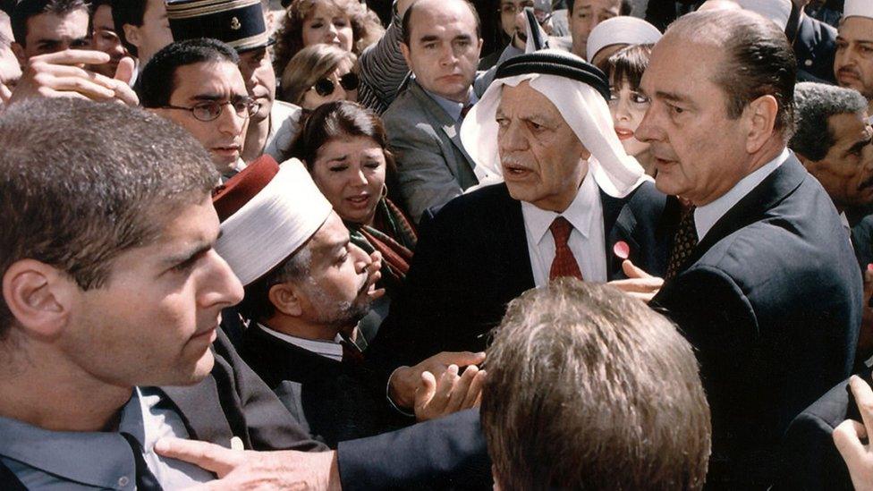 French President Jacques Chirac puts his hand on an Israeli security guard in Jerusalem on 22 October 1996