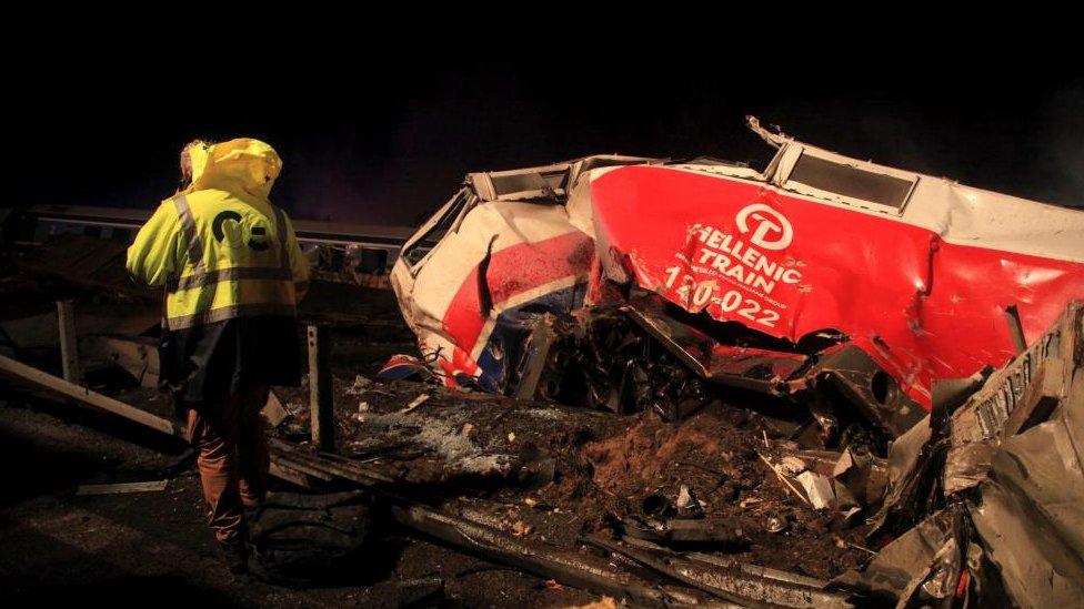 A rescue worker stands next to the smashed train