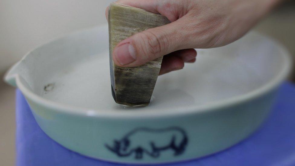 A man grinds a piece of rhino horn in Hanoi on April 24, 2012