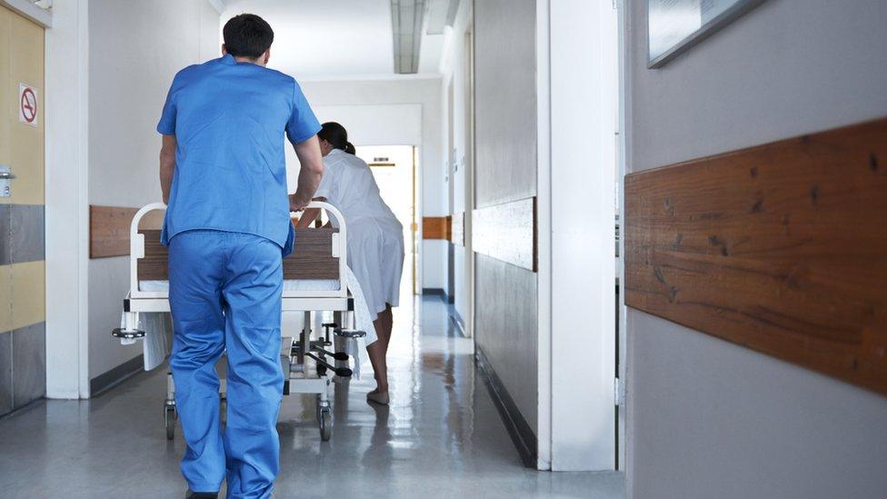 Male nurse pushing trolley