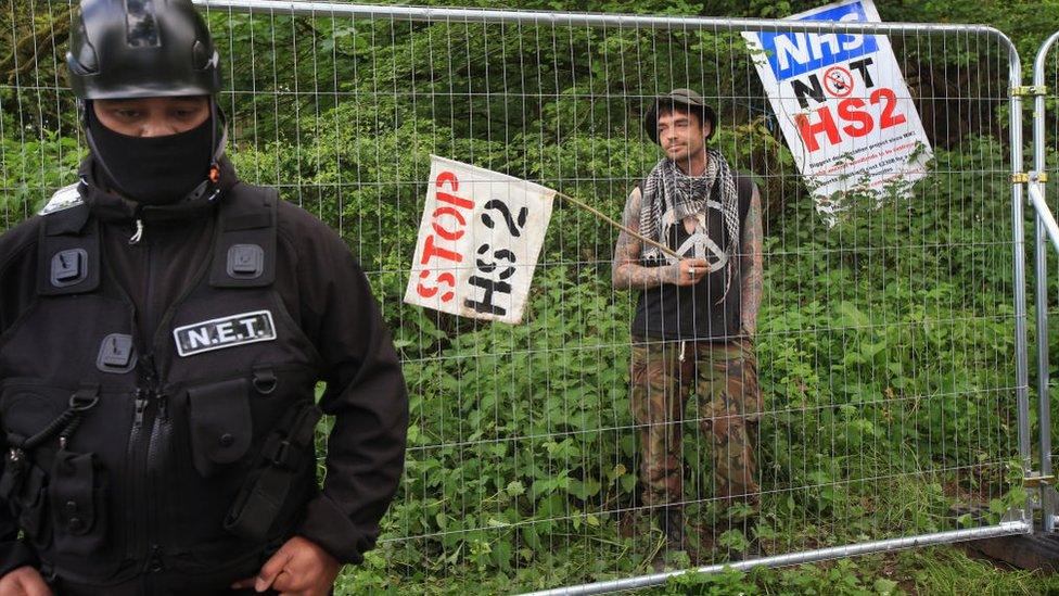 A National Eviction Team security patrol outside the fenced off woodland of a protest camp in Bluebell Wood in Staffordshire in May 2022