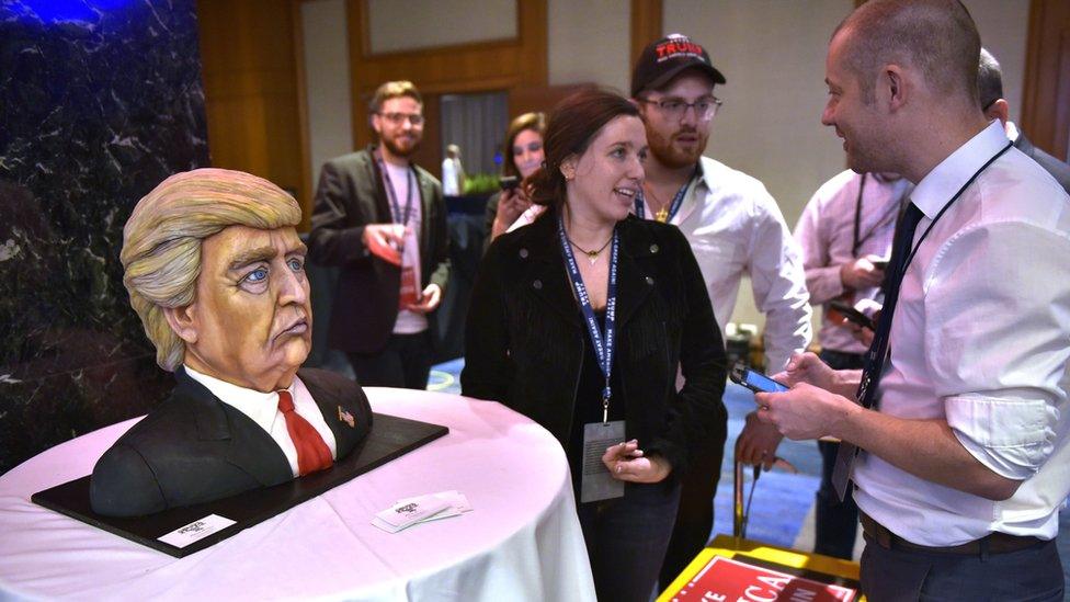 a woman shows a cake at election night trump HQ