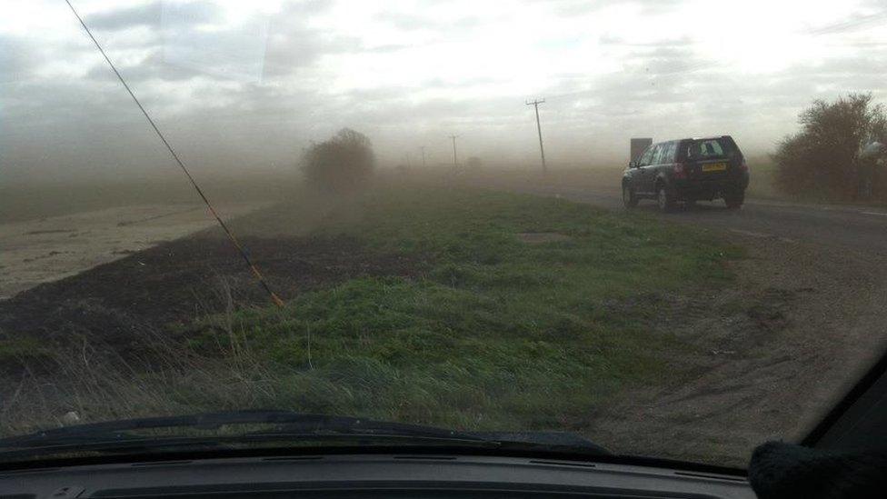 Mud blown across a road in Cambridgeshire