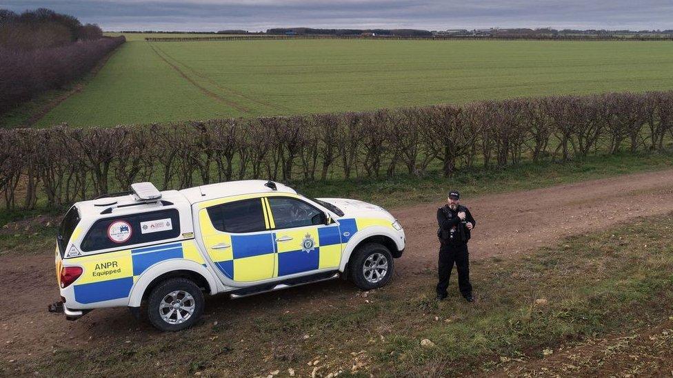 Police officer standing next to patrol car