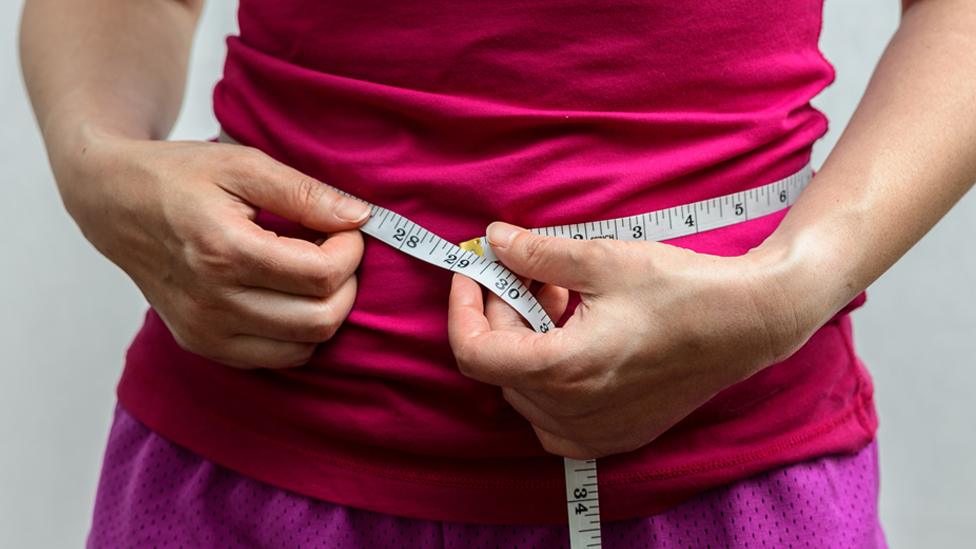 Woman measuring her waist