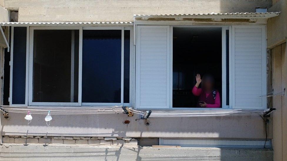 Woman in apartment waves to police drone