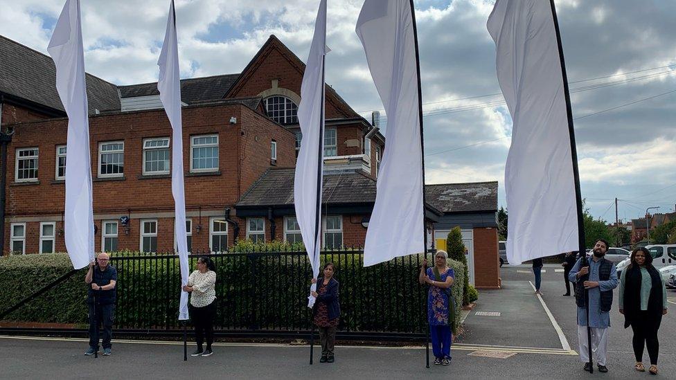 A group of people holding scrolls in Wolverton, Buckinghamshire