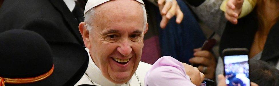 Pope Francis greets people during his weekly general audience at the Paul VI audience Hall on December 7,