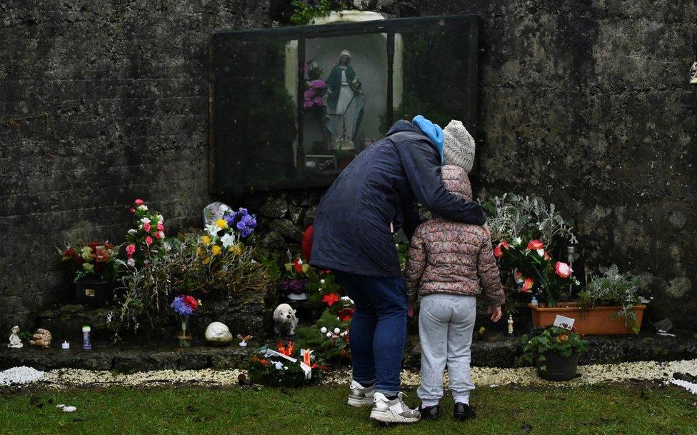 A mother and her daughter pay their respects at the Tuam graveyard where the bodies of 796 babies were uncovered