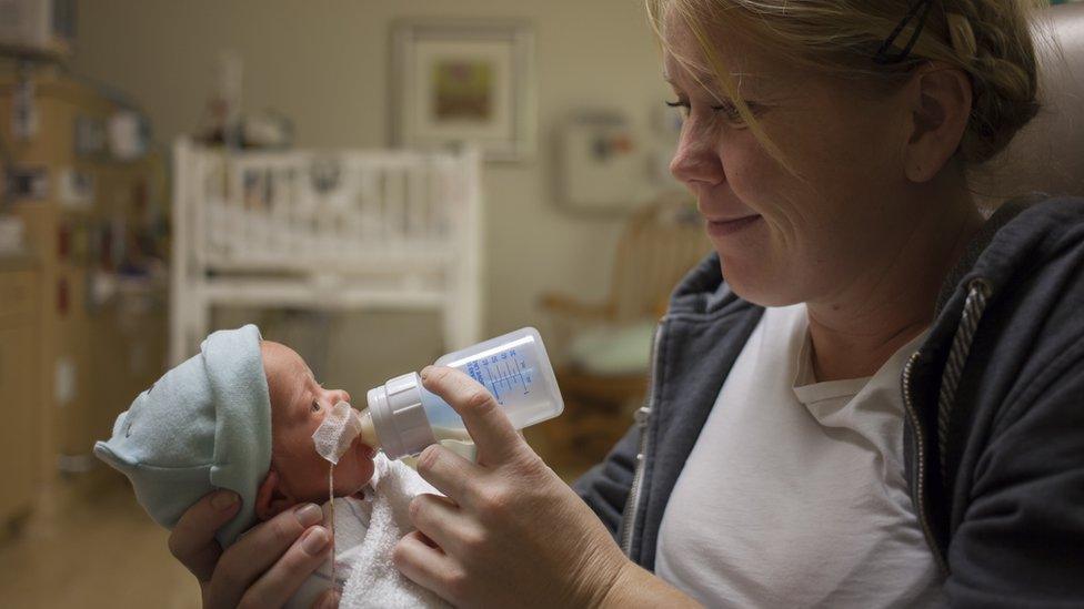 Mother feeding premature baby