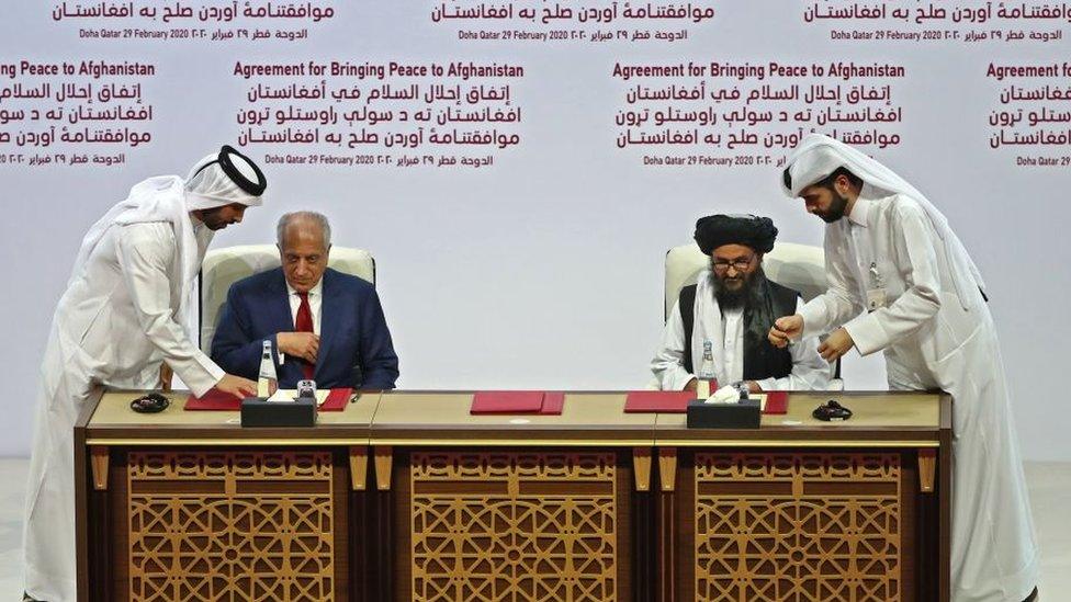 US Special Representative Zalmay Khalilzad and Taliban co-founder Mullah Abdul Ghani Baradar sign the peace agreement in February 2020