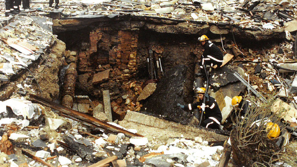 Firefighters search a crater caused by the blast