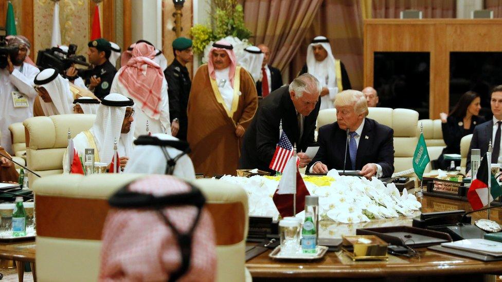 US Secretary of State Rex Tillerson (standing) hands President Donald Trump a note at a Gulf Co-operation Council summit in Riyadh, Saudi Arabia (21 May 2017)