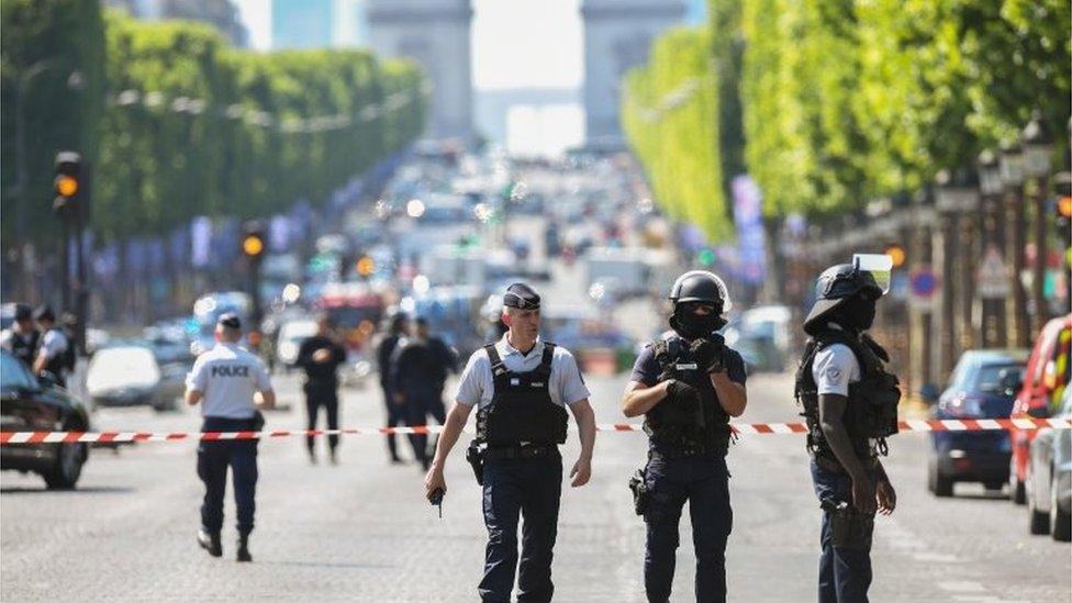 Police officers and anti-riot police officers patrol the Avenue des Champs-Élysées on 19 June 2017