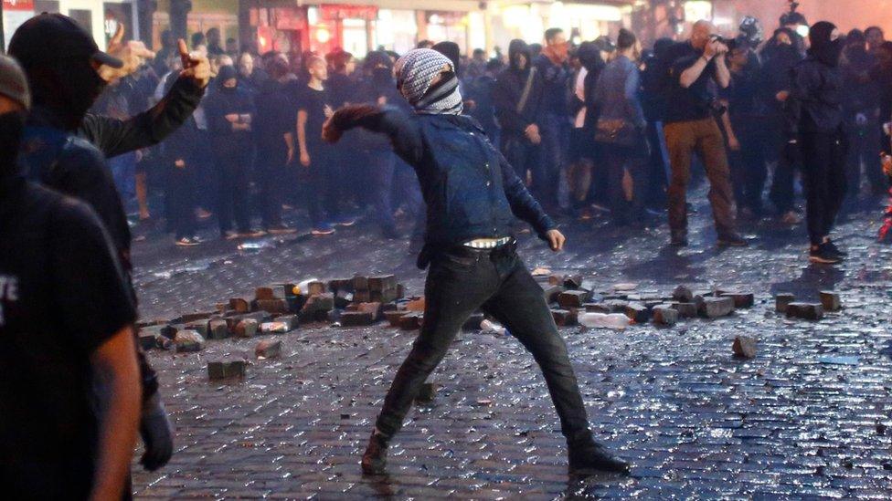 A protester goes to throw something in Hamburg