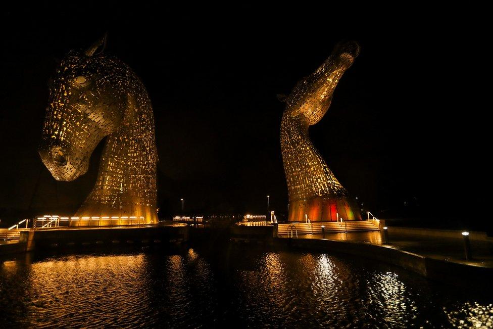 The Kelpies sculpture is illuminated in yellow, as part of a day of reflection to mark the anniversary of Britain"s first coronavirus disease (COVID-19) lockdown, in Falkirk, Scotland, Britain March 23, 2021.