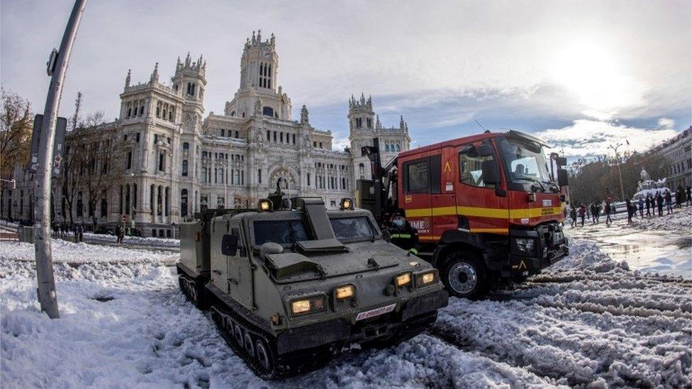 Members of the Spanish Military Emergencies Unit (UME) clear the snow at Cibeles Square in Madrid, Spain.