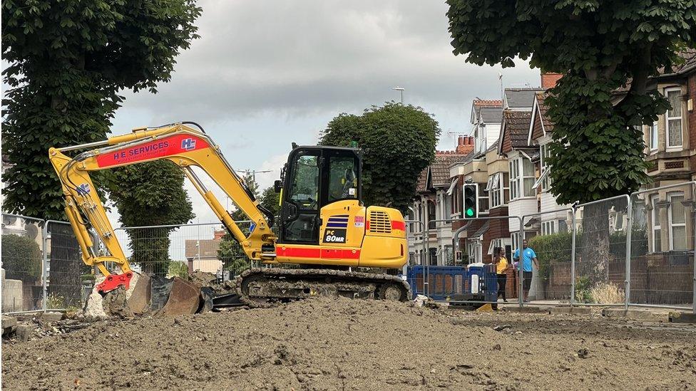 A digger and lots of fencing around the area being worked on