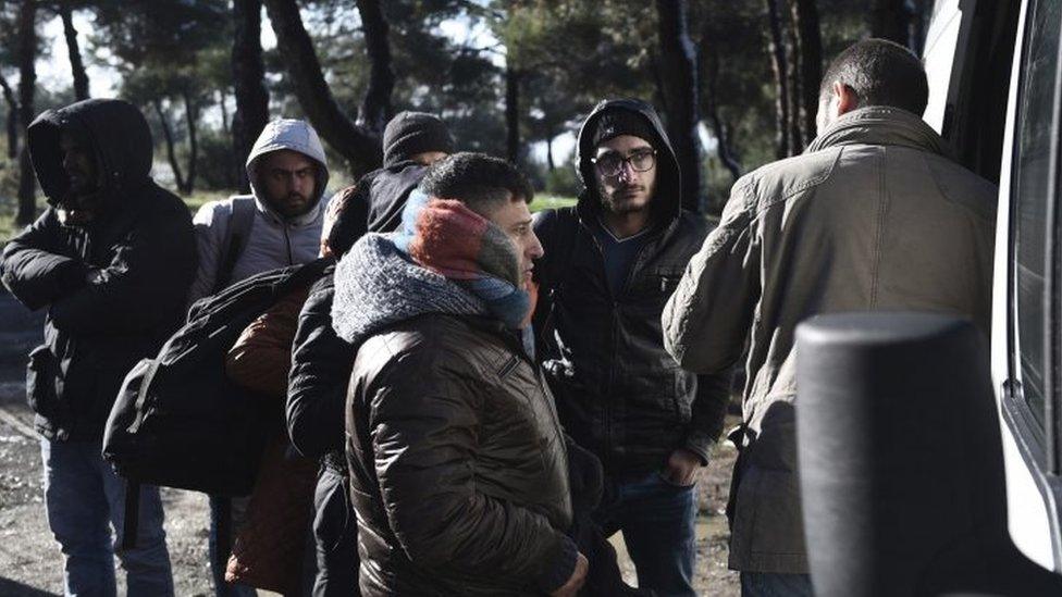 Syrian refugees embark board a police vehicle on the outskirts of the northern Greek city of Thessaloniki (30 November 2016)