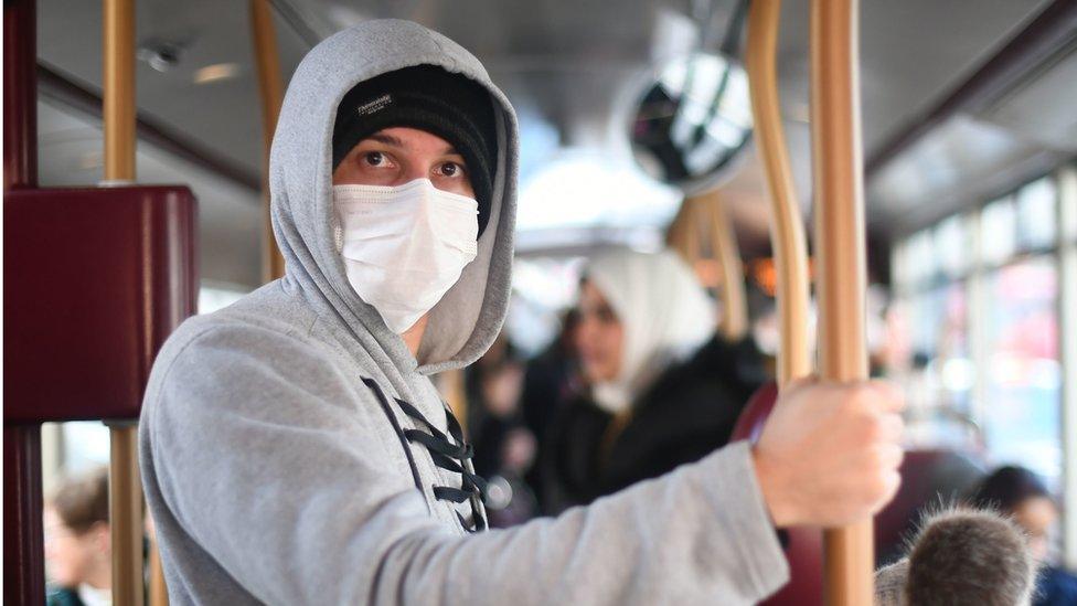 Passenger wears a protective facemask while taking a bus in Westminster