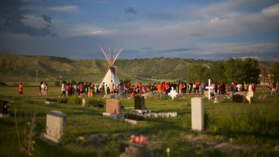 Hundreds of people gather for a vigil in a field where human remains were discovered in unmarked graves at the site of the former Marieval Indian Residential School on the Cowessess First Nation in Saskatchewan on June 26, 2021