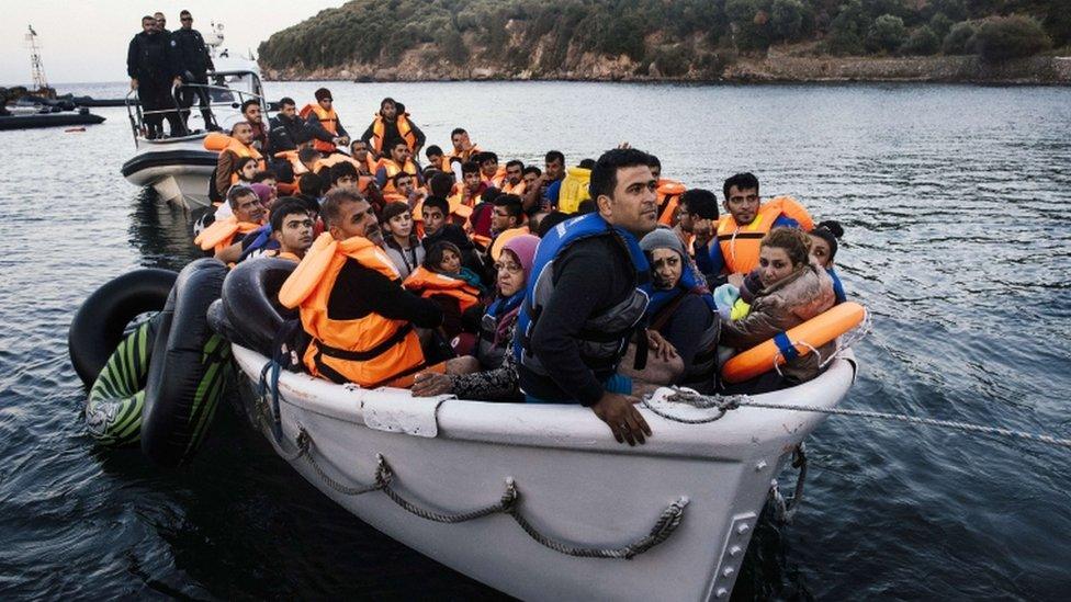 Representatives of the EU"s border management agency Frontex escort a boat with migrants and refugees who were trying to cross the Aegean Sea from Turkey