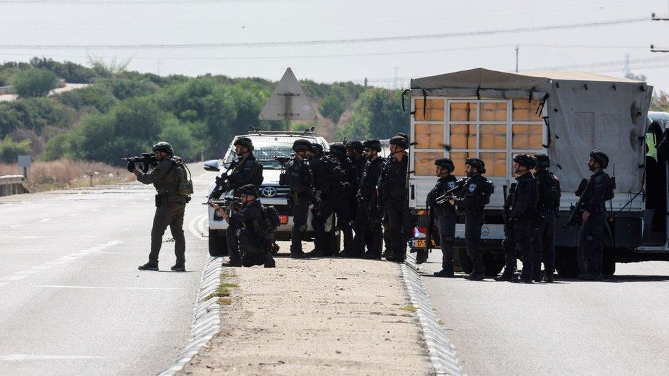 Israeli security forces aim their weapons, as rockets are launched from the Gaza Strip, near Ashkelon, southern Israel October 7, 2023.