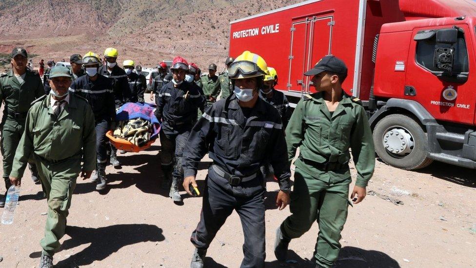 Rescue workers carry the body of a victim killed in the village of Talat Talat N'Yaaqoub