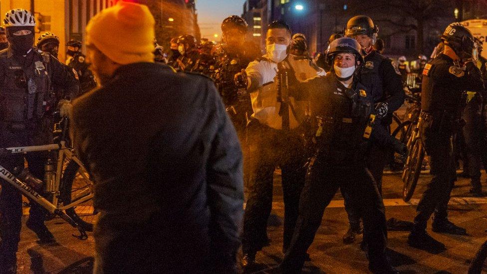 A member of the Proud Boys is pepper sprayed by the police after a confrontation with counter-protesters in Washington DC, on December 12, 2020