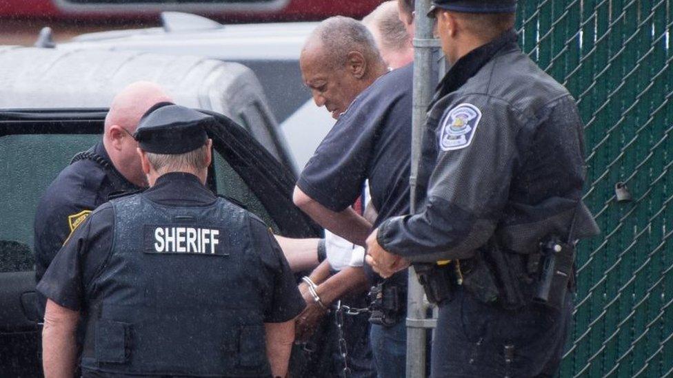 Handcuffed Bill Cosby (centre) is taken to Montgomery County Correctional Facility