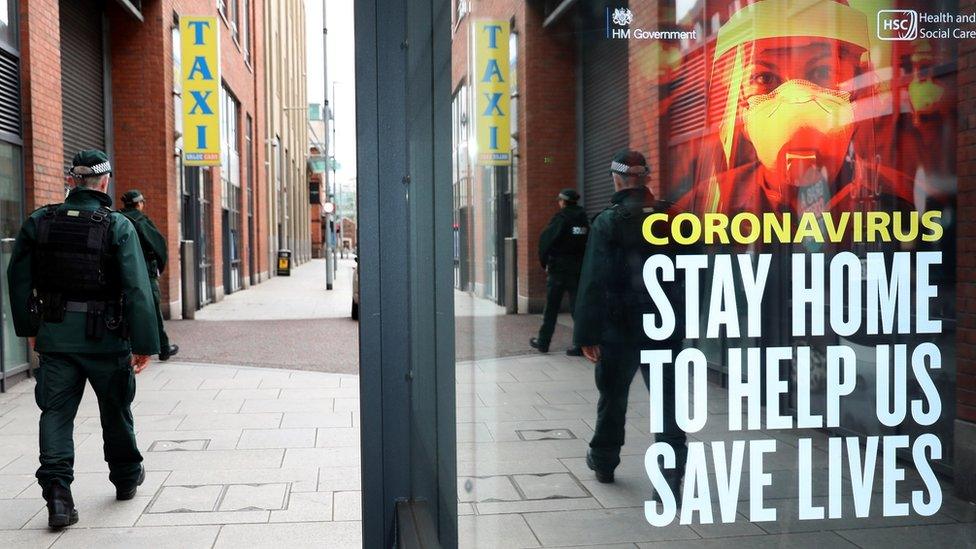 PSNI officer walking past a Covid-19 poster