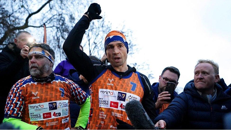 Sinfield raises his arm after completing the race