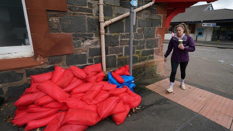 woman-walking-near-sandbags.