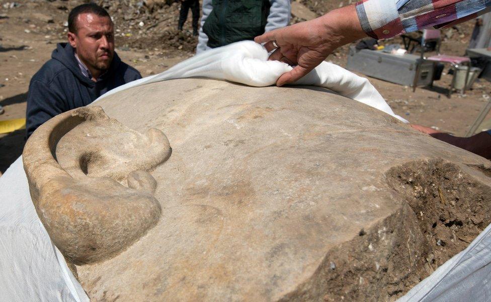 Antiquities workers cover the head of a massive statue, that may be of pharaoh Ramses II, one of the country"s most famous ancient rulers, which was found in groundwater in a Cairo slum, Egypt, Monday, March 13, 2017