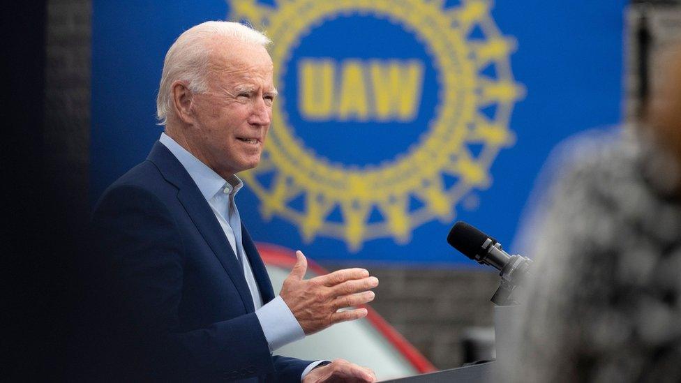 Joe Biden in front of a UAW sign