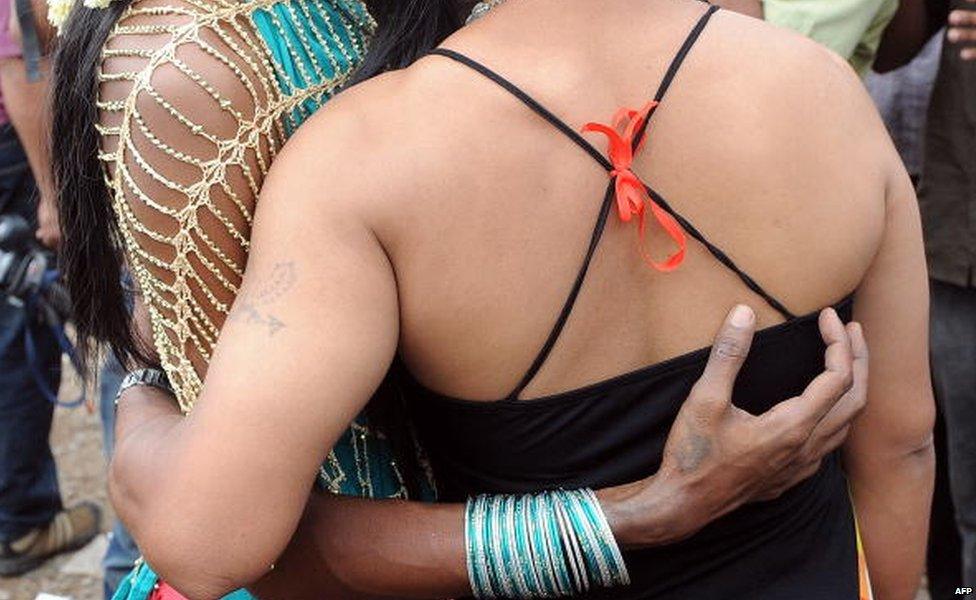 Indian members and supporters of the lesbian, gay, bisexual, transgender (LGBT) community hold placards as they walk underneath a rainbow flag during a Gay Pride Parade in New Delhi on November 30,2014