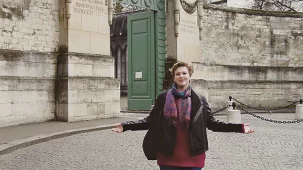 A young Georgie before he accident standing in front of a stone wall and gate