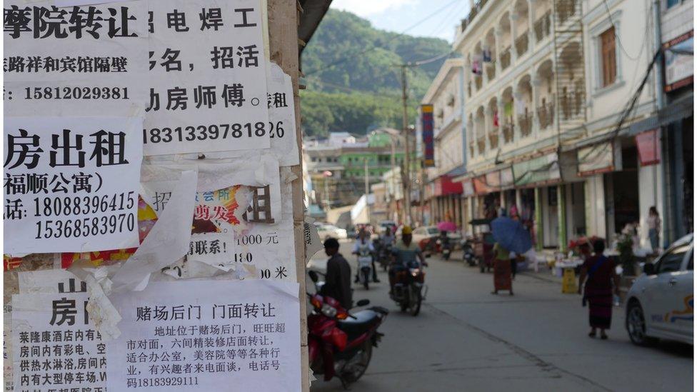 Paper posters in Chinese by the side of a street.